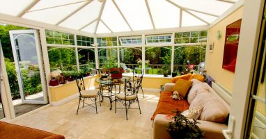 A conservatory in Basingstoke with sofas and tables and clear view of the garden.